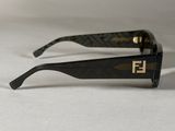 black and gold sunglasses on a white surface with a white background