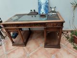une table en bois avec un plateau en verre, sur laquelle se trouve un vase