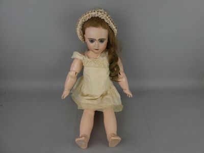 une poupée qui porte une robe et un chapeau