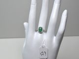 une main sur laquelle est passée une bague, à laquelle est accrochée une étiquette
