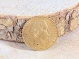 une image représentant une pièce d'or posée sur un morceau de bois