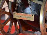 a black vase with a sign on it sitting on a wheel