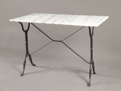 une table avec un plateau en marbre blanc, des pieds en fer et un piètement noir