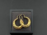 a pair of gold hoop earrings in a black box