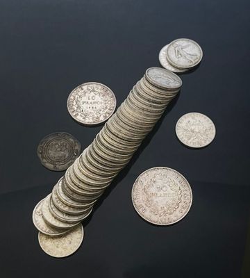 several coins sitting on top of a black table next to a stack of coins