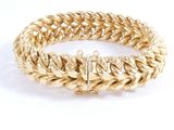 a close up of a gold bracelet on a white background