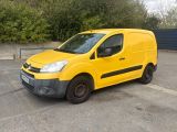 La camionnette jaune est garée sur le parking, près des arbres.