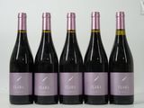 six bouteilles de vin sont alignées sur une table