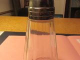 un salière et une poivrière en verre posées sur une serviette rose