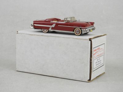 une vieille maquette de voiture rouge posée sur une boîte