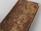 an old book sitting on top of a table next to a white table