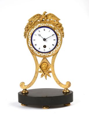 une horloge posée sur un support sur une surface blanche