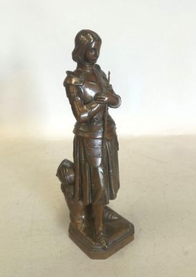 figurine en bronze représentant une femme tenant un chien, posée sur un socle