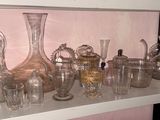 de nombreux vases en verre posés sur une étagère dans une pièce