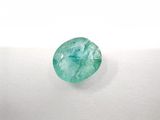a close up of a green emerald stone on a white surface