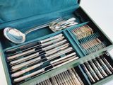 a green case with silverware in it on a white surface