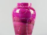 a pink vase that is sitting on a table