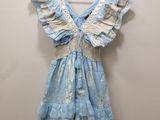 une robe bleue et blanche suspendue à un cintre contre un mur