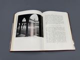 un livre ouvert sur lequel figure la photo en noir et blanc d'un bâtiment