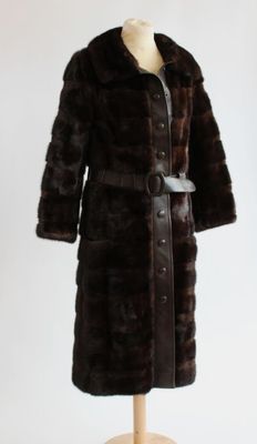 un manteau de fourrure marron posé sur un mannequin, sur fond blanc