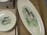 two plates with fish painted on them sitting on a table