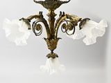 un lustre doré d'où pendent des fleurs blanches