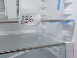 a white refrigerator with the door open and a blue tape on the door