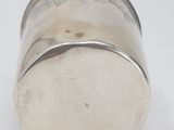 silver plated salt shaker on a white surface with a white background