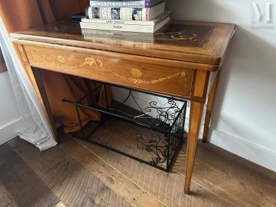 une petite table sur laquelle sont posés des livres, près d'une fenêtre