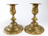 pair of antique brass candlesticks on pedestals on a white background