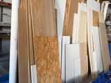 Plusieurs panneaux de contreplaqué sont empilés dans un entrepôt