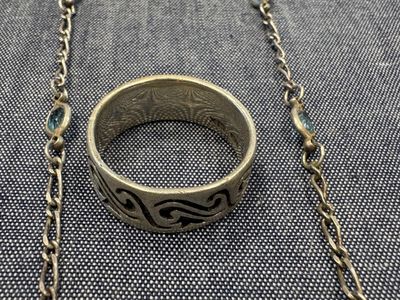 un gros plan d'une bague suspendue à une chaîne posée sur une table