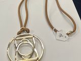 collier en argent et en or, orné d'un motif circulaire, monté sur un cordon marron