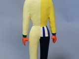 figurine représentant un homme en costume jaune et bleu, debout sur un bloc