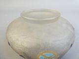 un vase blanc orné d'un motif bleu et jaune