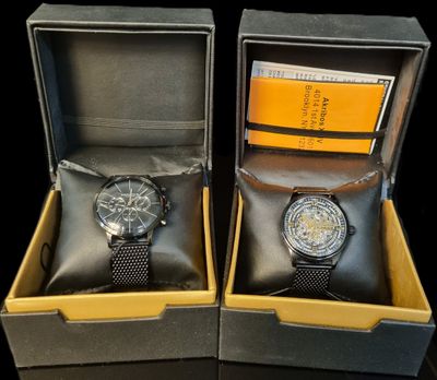 two watches sitting in a box on a table