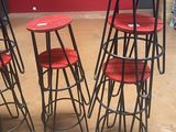 four red stools sitting on top of each other in front of a red wall