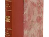 un vieux livre à la couverture rouge posé sur une surface blanche