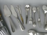 a lot of silver spoons and forks on the table