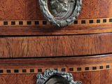 an image of a wooden chest of drawers with metal knobs