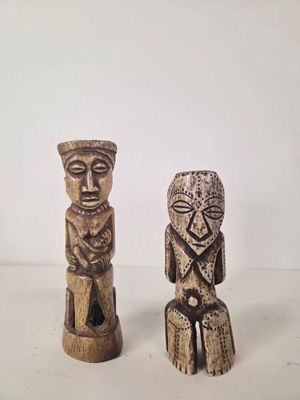pair of carved wooden figurines of a man and a woman