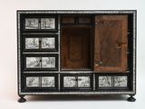 a black and white chest of drawers with pictures on it