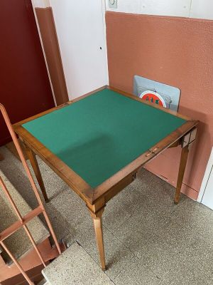 une table recouverte d'un tissu vert, près d'un escalier