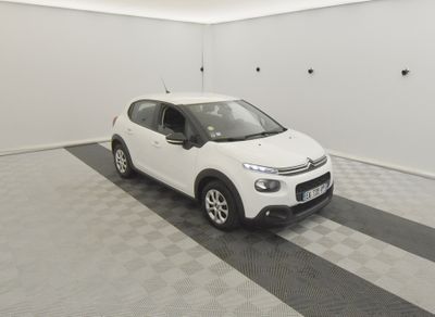 the small white car is parked in a clean room