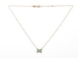 a gold necklace with a green butterfly pendant on a chain