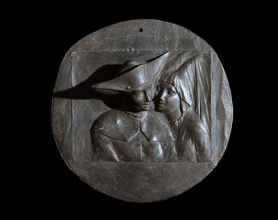 a bronze plaque of a man and a woman on a black background
