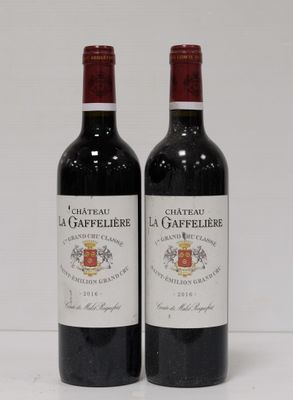 two bottles of red wine sitting next to each other on a table