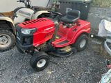 a red riding lawn mower parked next to a dumpster