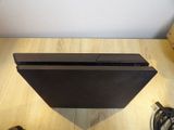 a black sony playstation game console sitting on a wooden table