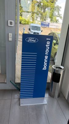un panneau bleu situé devant une porte vitrée